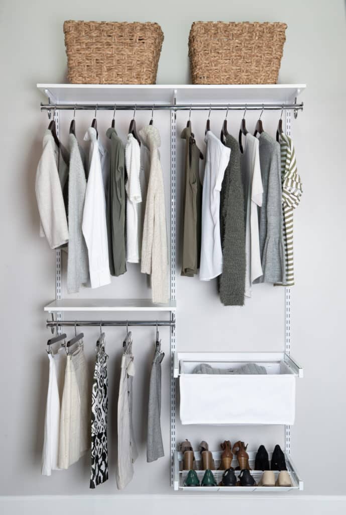 Neatly organized closet with clothes, shoes, and baskets on shelves.