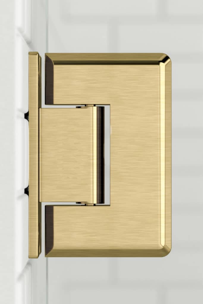 Brushed gold handle on a white shower door.