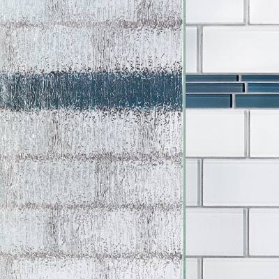 A textured glass shower door next to a smooth tiled wall.