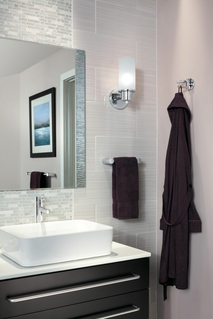 Modern bathroom interior with a vessel sink, wall-mounted faucet, elegantly draped towel, and stylish bath accessories.
